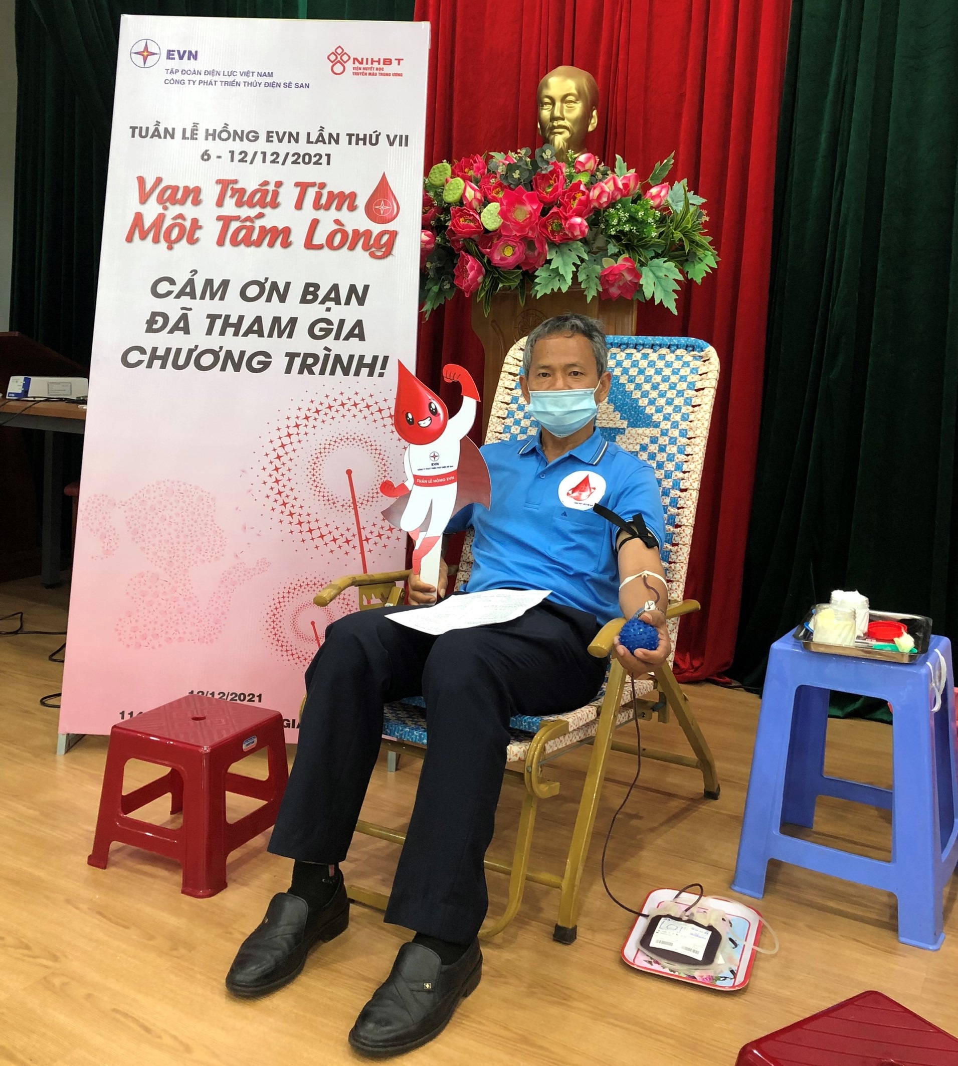 A person in a mask sitting in a chair with a catDescription automatically generated with low confidence