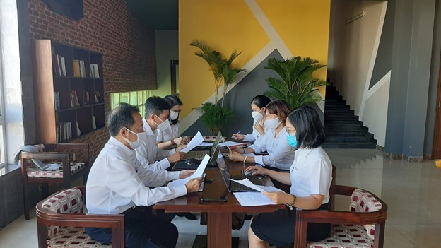 A group of people sitting around a tableDescription automatically generated with medium confidence