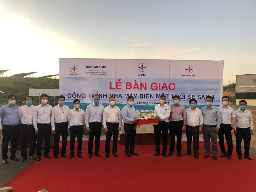 A group of people standing in front of a large bannerDescription automatically generated with medium confidence