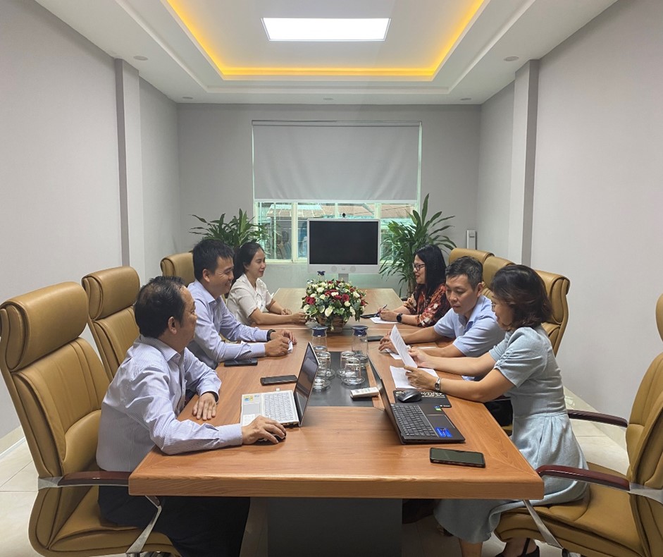 A group of people sitting around a table with laptopsDescription automatically generated