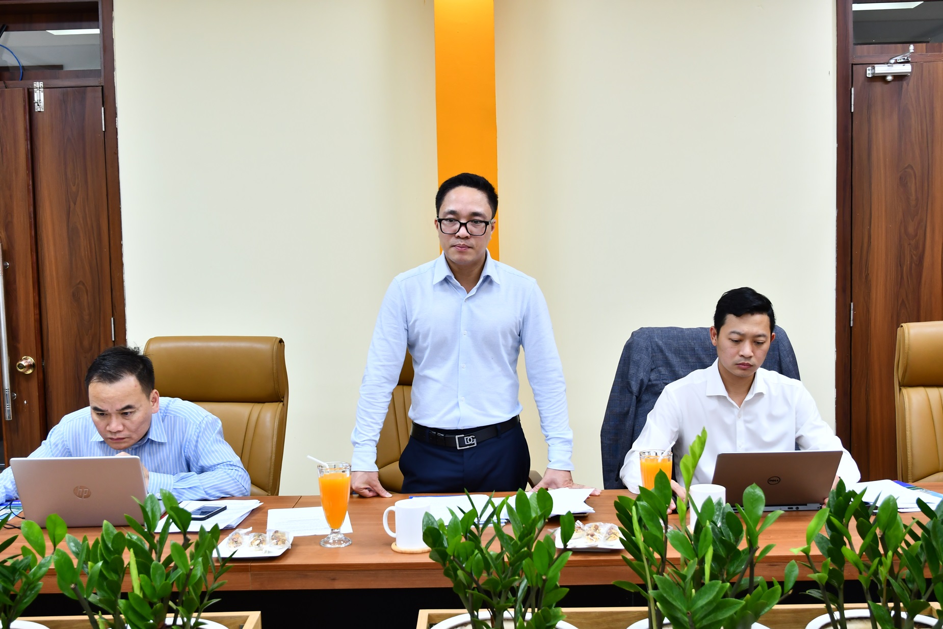 A group of men sitting at a table with laptopsDescription automatically generated