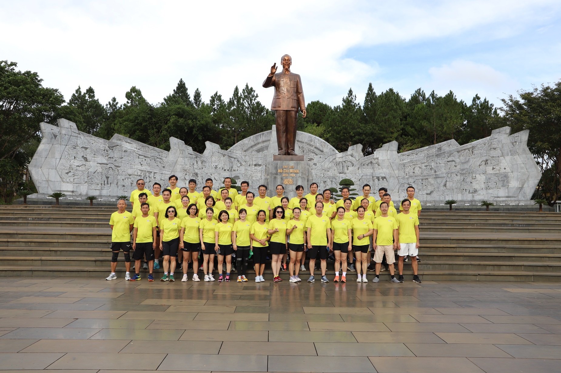 A group of people in yellow shirts posing for a photoDescription automatically generated