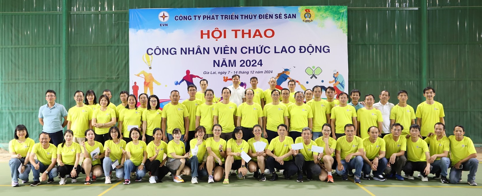 A group of people in yellow shirts posing for a photoDescription automatically generated