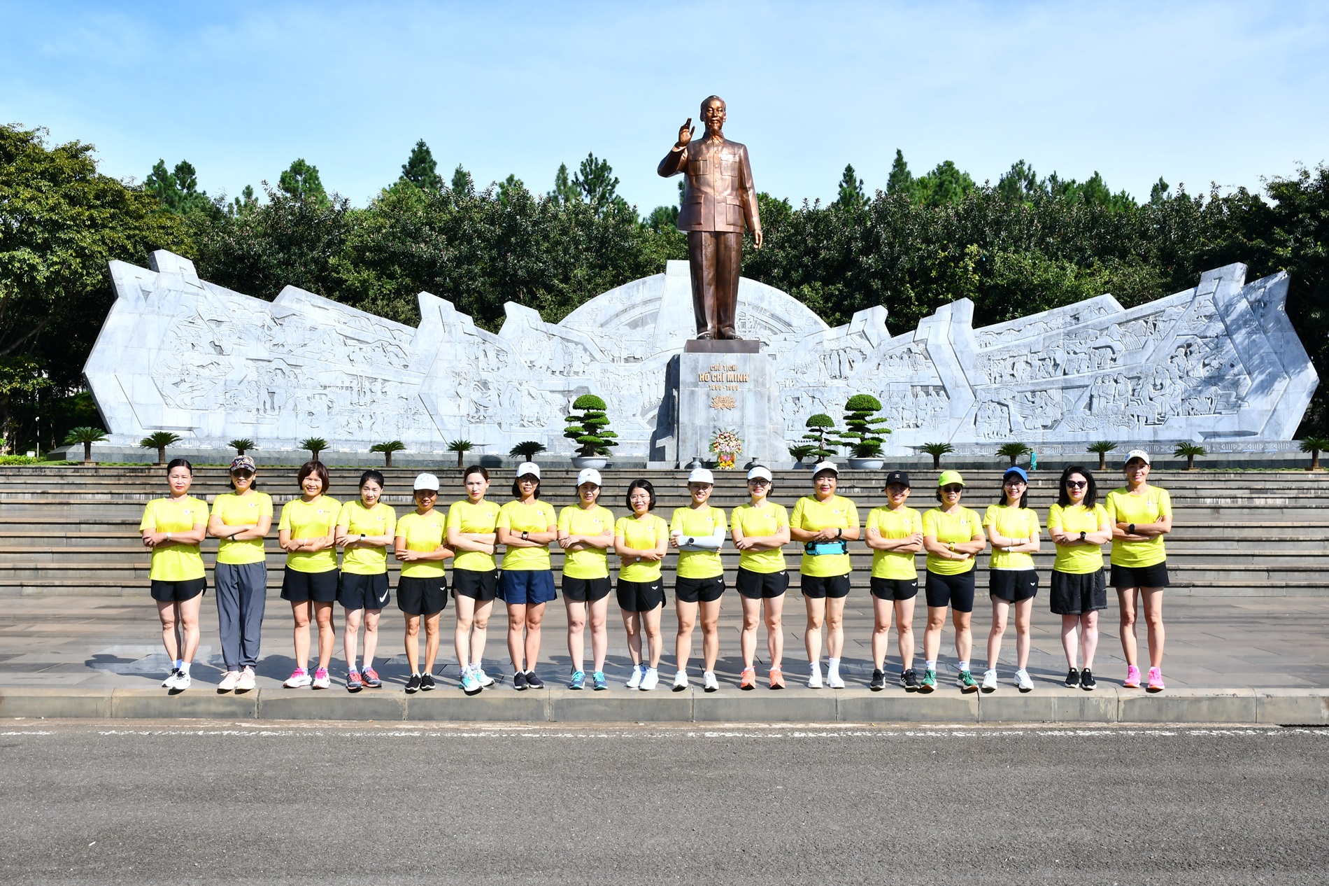 A group of people standing in front of a statueDescription automatically generated