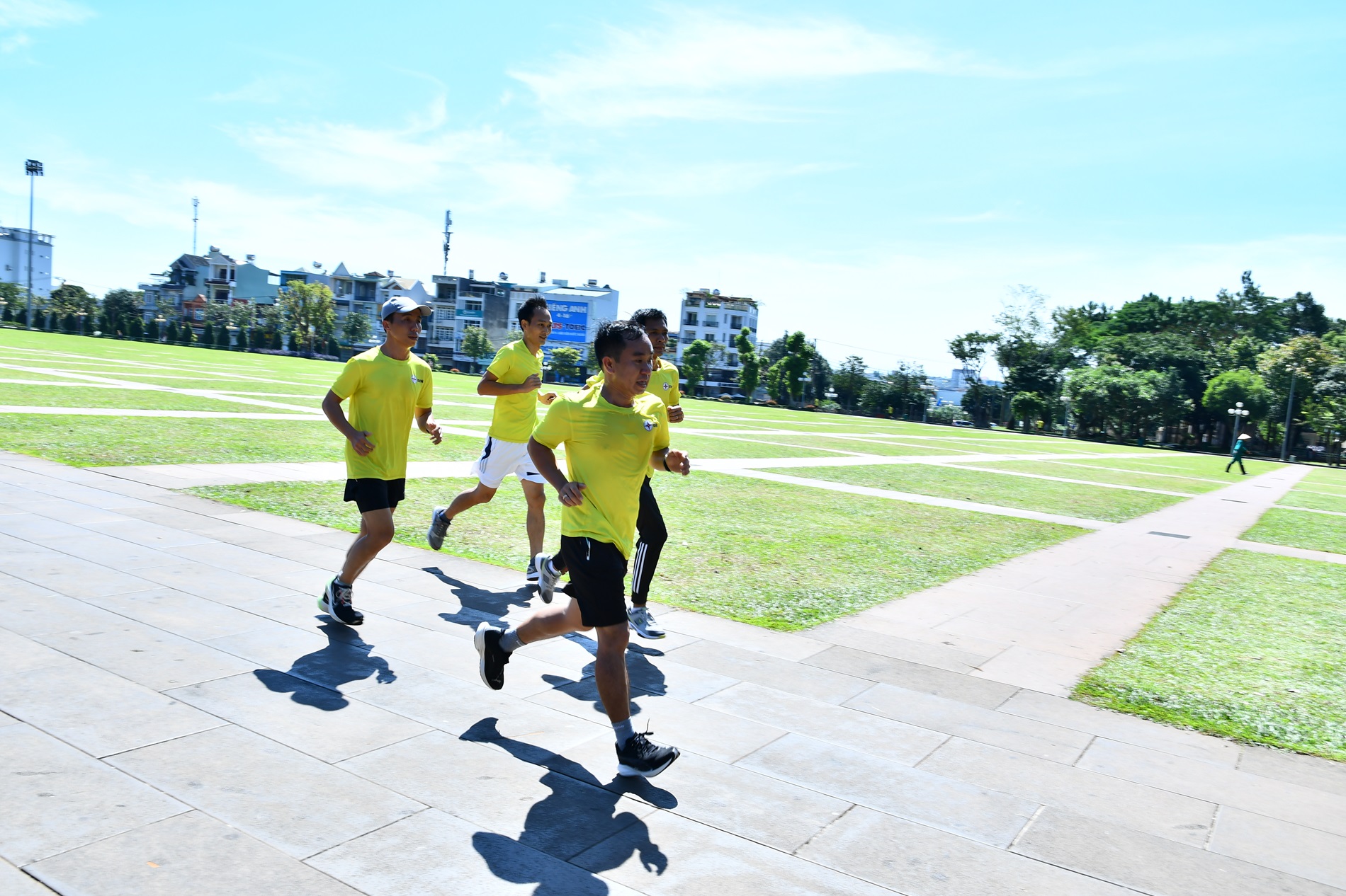 A group of people running on a sidewalkDescription automatically generated