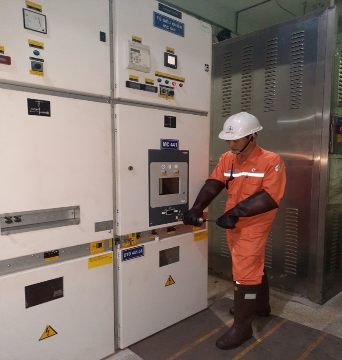 A person wearing a hard hat and glovesDescription automatically generated